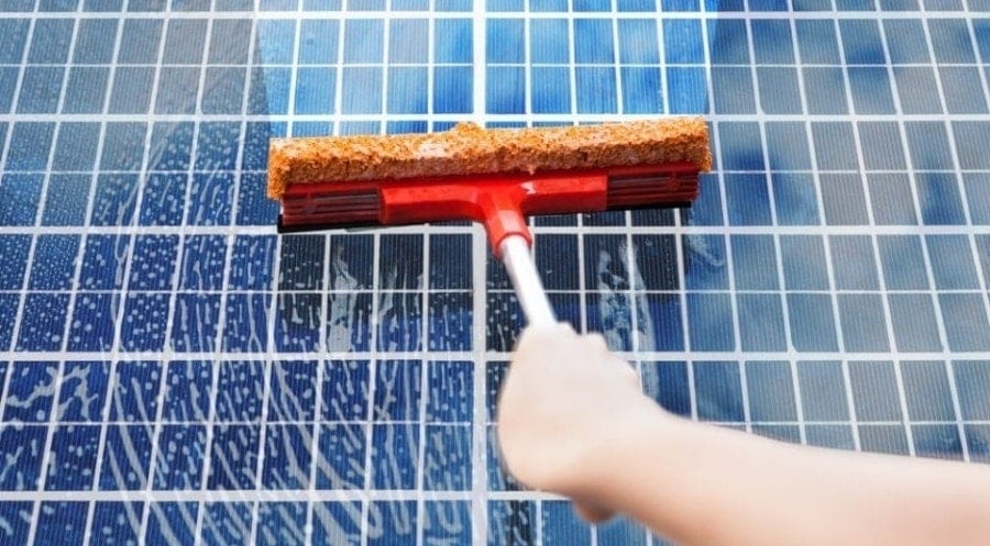person cleaning solar panels
