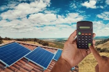 solar panels on a house and a man with a calculator