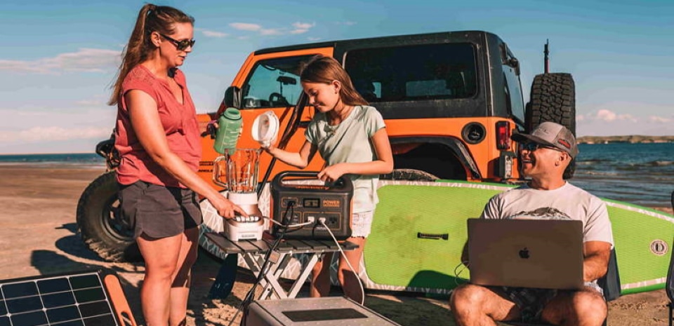 a family on the beach using a solar generator