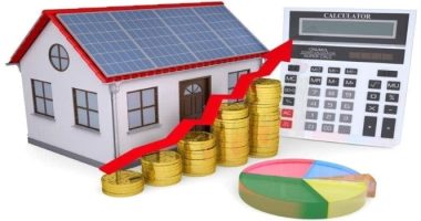 a house with solar panels and a calculator with money