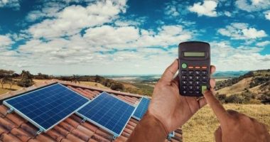 solar panels on a house and a man with a calculator
