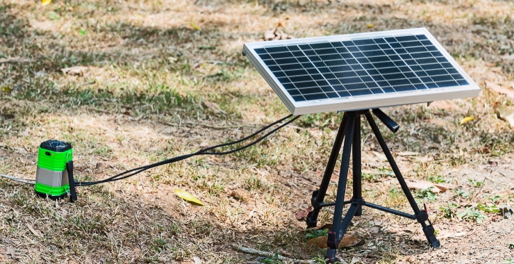 portable solar panel outdoors charging a lamp