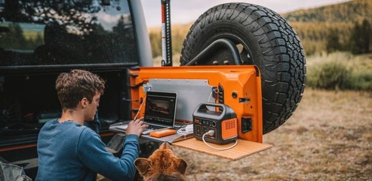 a guy uses a solar generator to charge his laptop