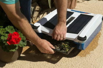 A man is emptying the solar powered pool cleaner